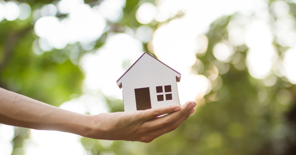 Woman hand, holding a house model